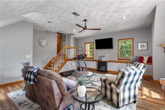 living room featuring baseboards, stairs, a fireplace, wood finished floors, and recessed lighting