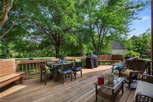 deck with outdoor dining space, grilling area, and outdoor lounge area