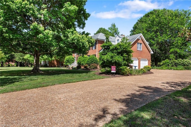 view of front facade with brick siding, a garage, and a front lawn