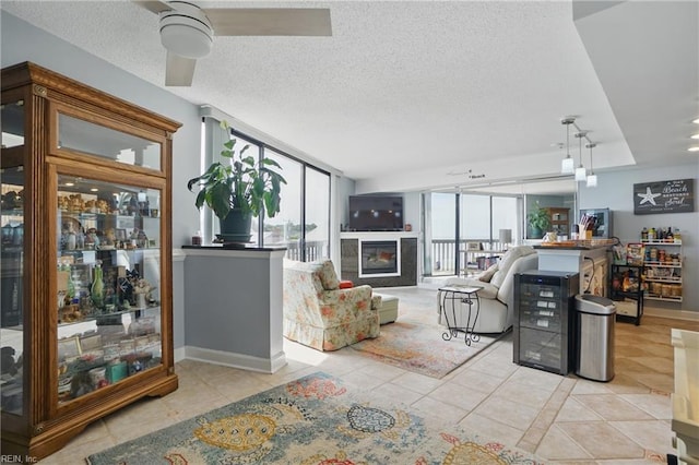 1222 E Ocean View Ave Unit 302, Norfolk, VA 23503 - living room with light tile patterned floors, a glass covered fireplace, a textured ceiling, and ceiling fan
