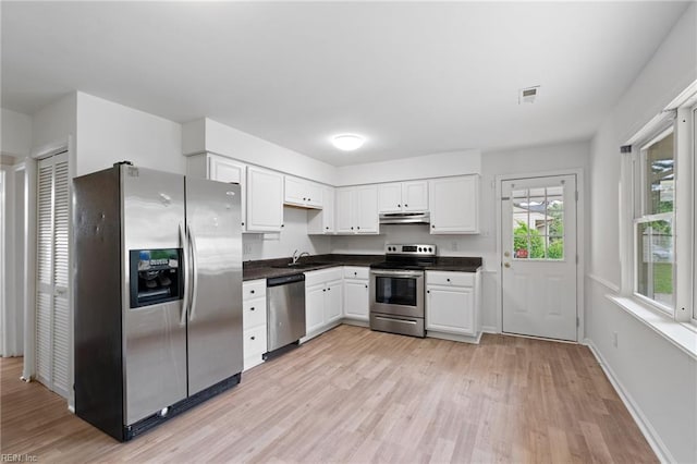 669 Kenneth Rd, Virginia Beach, VA 23462 - kitchen with stainless steel appliances, under cabinet range hood, a sink, dark countertops, and light wood-style flooring