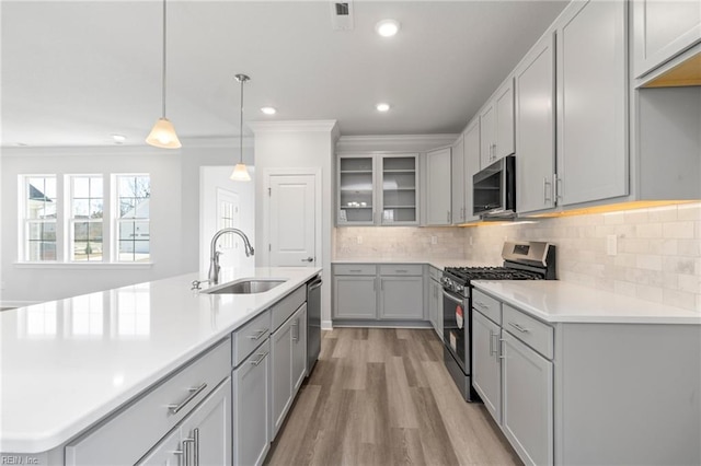2237 Sanibel Ln, Chesapeake, VA 23321 - kitchen with stainless steel appliances, a sink, crown molding, light countertops, and light wood finished floors