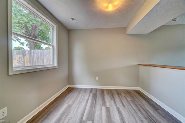 913 Fluvanna Rd, Newport News, VA 23601 - spare room with wood finished floors, a textured ceiling, and baseboards