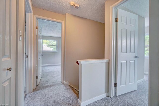913 Fluvanna Rd, Newport News, VA 23601 - hall featuring carpet floors, a textured ceiling, an upstairs landing, and baseboards