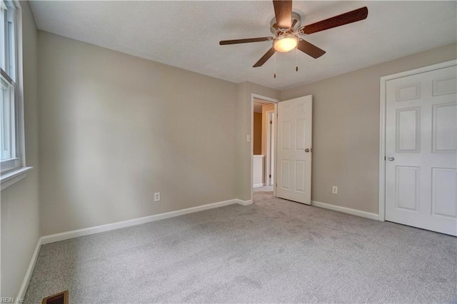 913 Fluvanna Rd, Newport News, VA 23601 - unfurnished bedroom with carpet, baseboards, multiple windows, and a ceiling fan