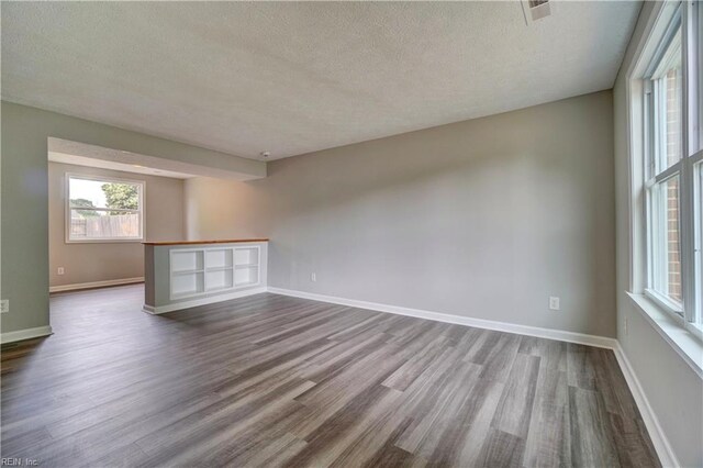 913 Fluvanna Rd, Newport News, VA 23601 - unfurnished room featuring a textured ceiling, dark wood-type flooring, healthy amount of natural light, and baseboards