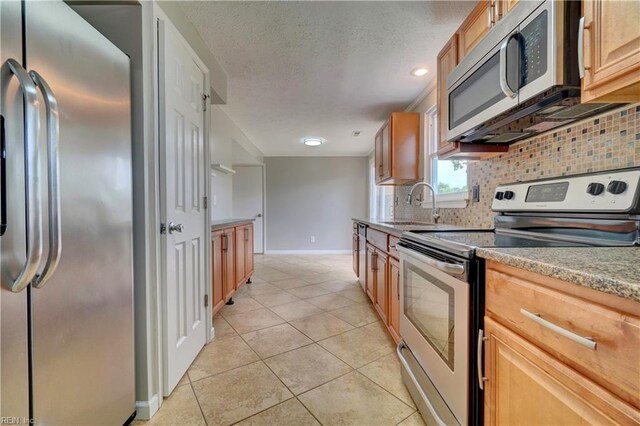 913 Fluvanna Rd, Newport News, VA 23601 - kitchen featuring appliances with stainless steel finishes, a sink, baseboards, decorative backsplash, and light tile patterned floors