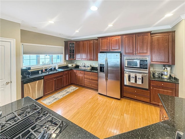 564 Riverside Dr, Lancaster, VA 22503 - kitchen featuring appliances with stainless steel finishes, ornamental molding, a sink, glass insert cabinets, and dark stone countertops