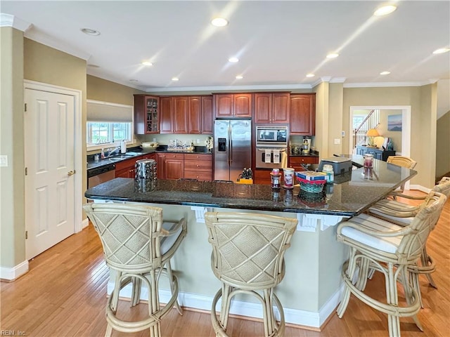 564 Riverside Dr, Lancaster, VA 22503 - kitchen with stainless steel appliances, ornamental molding, a kitchen bar, light wood-style flooring, and glass insert cabinets