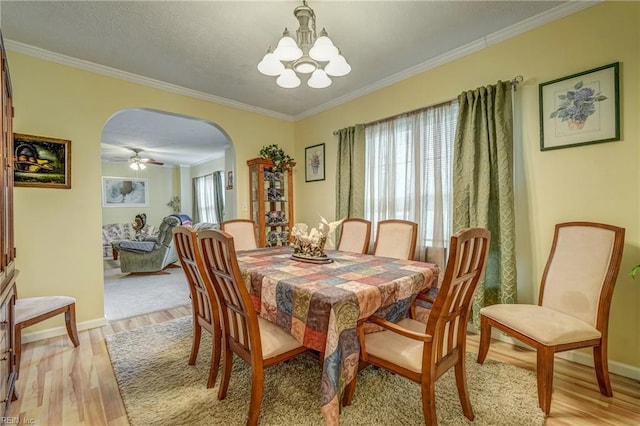 10402 Freewelcome Ln, Gloucester, VA 23061 - dining area featuring arched walkways, a chandelier, light wood-style flooring, crown molding, and baseboards