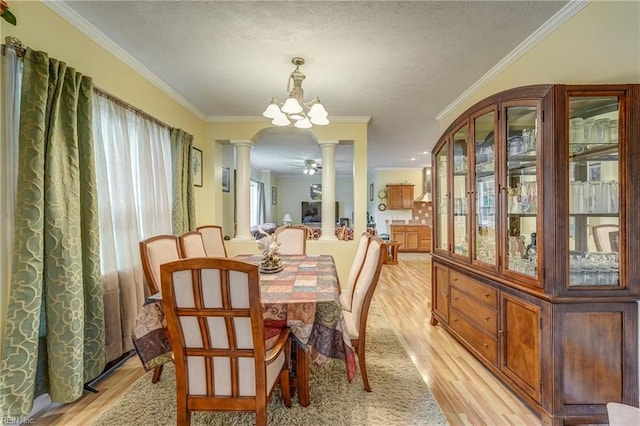 10402 Freewelcome Ln, Gloucester, VA 23061 - dining area featuring ornate columns, light wood-type flooring, a textured ceiling, and crown molding