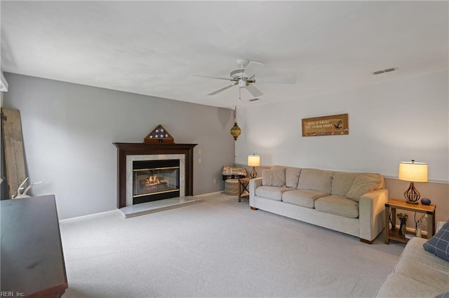 carpeted living area with a ceiling fan and a high end fireplace