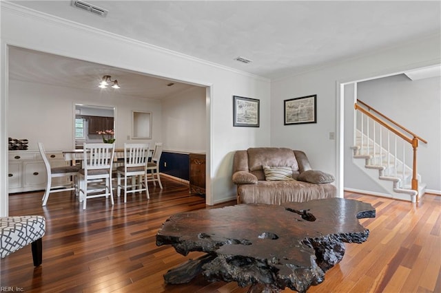 living room with wood-type flooring, crown molding, stairway, and baseboards