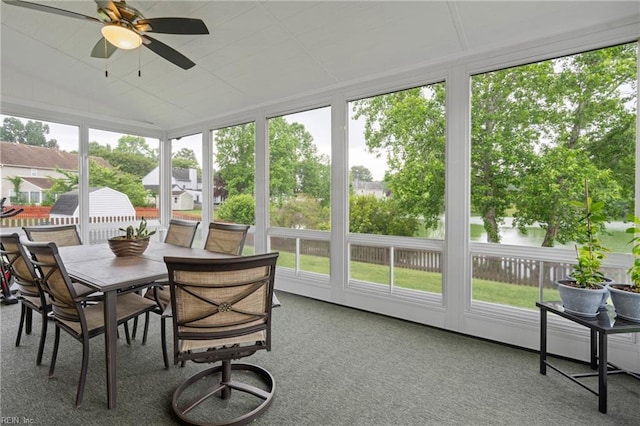 sunroom with ceiling fan, carpet flooring, and outdoor dining space