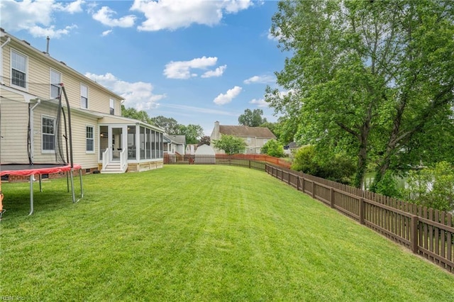 view of yard with a trampoline, a sunroom, and entry steps