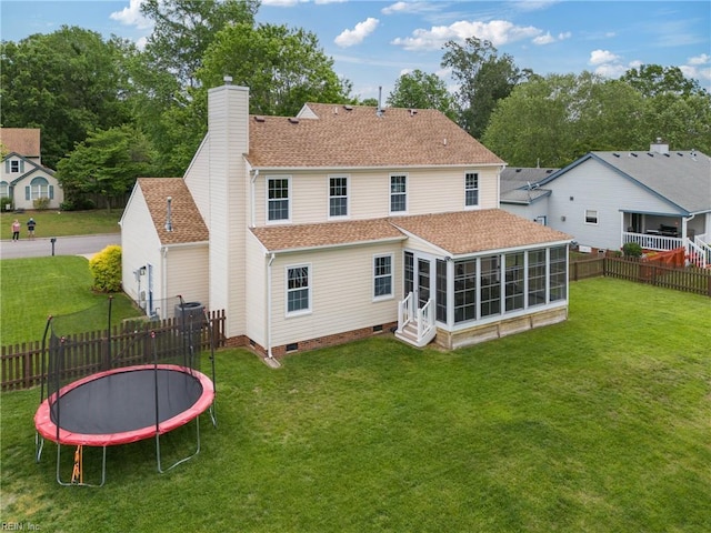 back of property with a trampoline, a sunroom, a chimney, crawl space, and roof with shingles