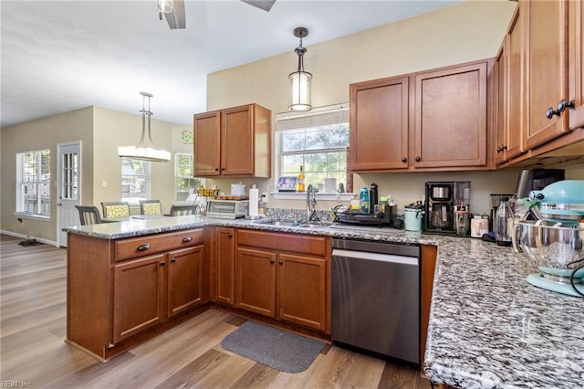 kitchen featuring dishwasher, a peninsula, light wood-type flooring, and a sink