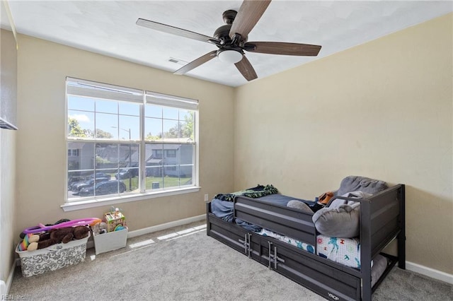 living area with baseboards, carpet, and a ceiling fan