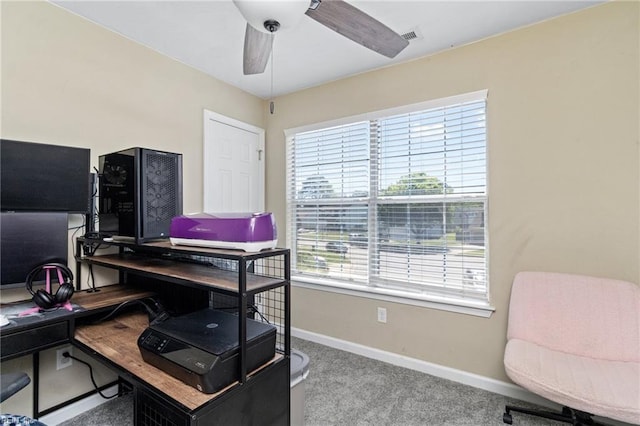 carpeted office space with baseboards and a ceiling fan