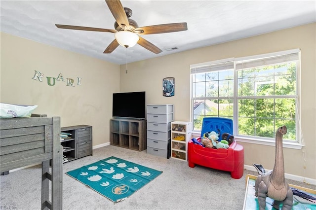 carpeted bedroom with multiple windows, ceiling fan, and baseboards