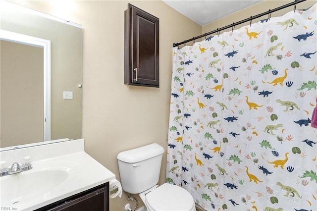 bathroom with toilet, vanity, and curtained shower
