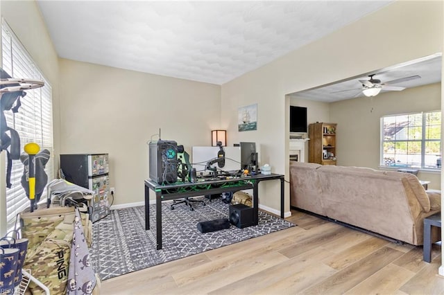 office area with wood finished floors, ceiling fan, and baseboards