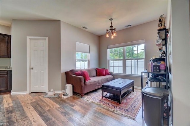 6884 Emerson Ln, Hayes, VA 23072 - living room featuring light wood finished floors, baseboards, and a chandelier