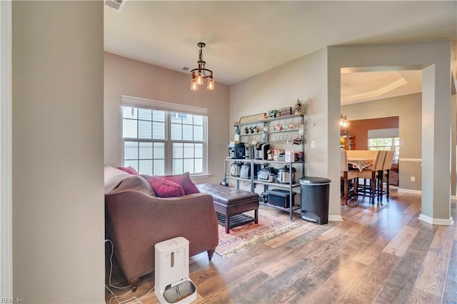 6884 Emerson Ln, Hayes, VA 23072 - living room with wood finished floors, a chandelier, and baseboards