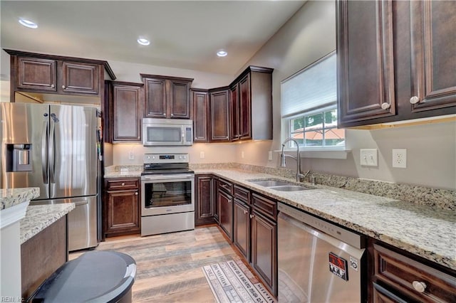 6884 Emerson Ln, Hayes, VA 23072 - kitchen with appliances with stainless steel finishes, a sink, light wood-style flooring, light stone countertops, and dark brown cabinets