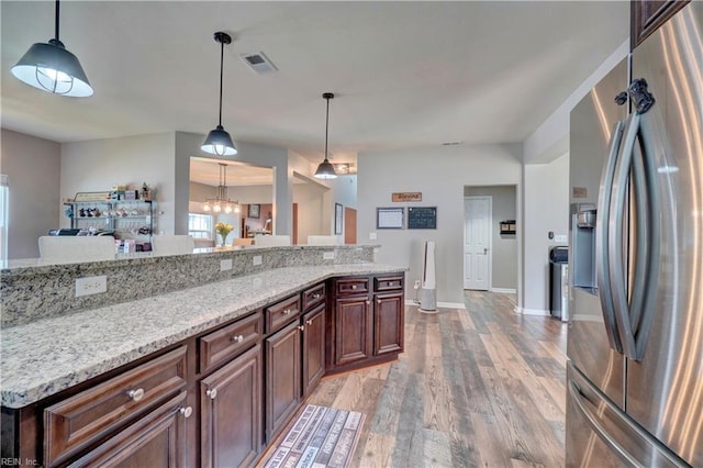 6884 Emerson Ln, Hayes, VA 23072 - kitchen with stainless steel refrigerator with ice dispenser, light wood finished floors, hanging light fixtures, light stone countertops, and baseboards