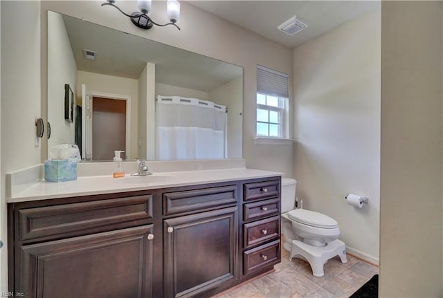 6884 Emerson Ln, Hayes, VA 23072 - bathroom featuring toilet, vanity, and baseboards