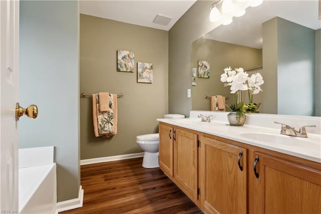 825 Wyemouth Dr, Newport News, VA 23602 - bathroom featuring wood finished floors, toilet, a bath, double vanity, and baseboards