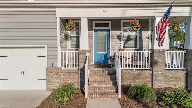 1951 Flintshire Dr, Chesapeake, VA 23323 - property entrance with a porch, driveway, an attached garage, and brick siding