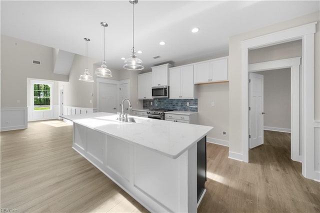 2094 Asher Dr, Suffolk, VA 23435 - kitchen featuring appliances with stainless steel finishes, a sink, white cabinets, decorative backsplash, and light wood-type flooring