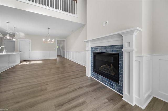 2094 Asher Dr, Suffolk, VA 23435 - unfurnished living room with a wainscoted wall, wood finished floors, a tiled fireplace, and a decorative wall