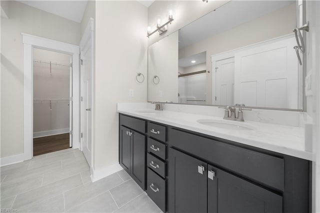 2094 Asher Dr, Suffolk, VA 23435 - full bath featuring double vanity, baseboards, a walk in closet, a stall shower, and tile patterned flooring