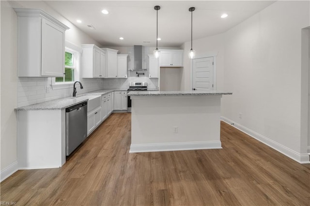 5376 Kenmere Ln, Smithfield, VA 23430 - kitchen featuring appliances with stainless steel finishes, wall chimney range hood, a sink, decorative backsplash, and white cabinetry