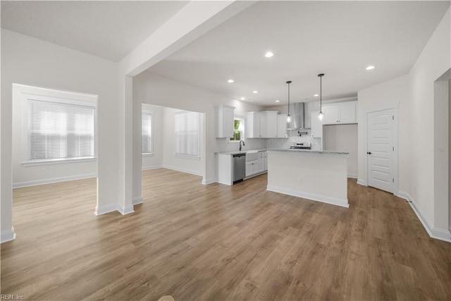 5376 Kenmere Ln, Smithfield, VA 23430 - kitchen featuring wall chimney exhaust hood, open floor plan, dishwasher, light countertops, and white cabinetry