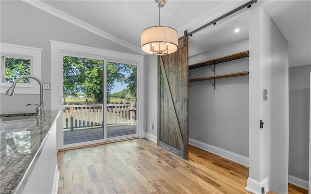 147 Ransone St, Hampton, VA 23669 - unfurnished dining area featuring a sink, a barn door, light wood-style floors, baseboards, and crown molding