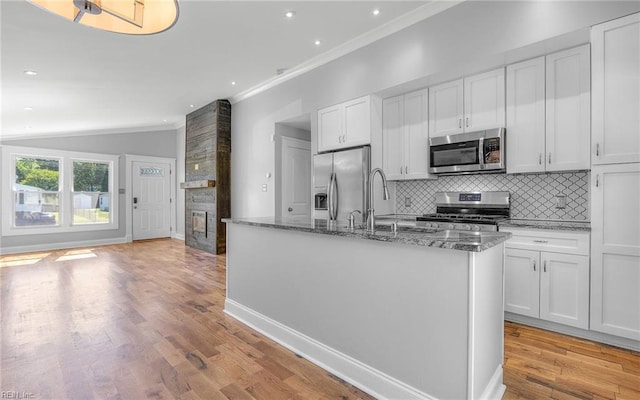 147 Ransone St, Hampton, VA 23669 - kitchen featuring stainless steel appliances, a sink, decorative backsplash, dark stone counters, and a center island with sink