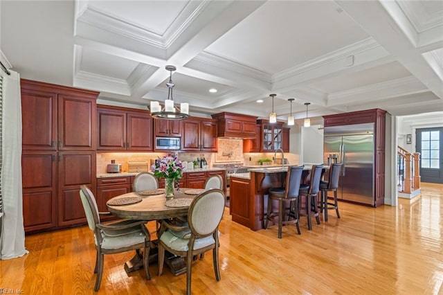 dining space with light wood-type flooring, beamed ceiling, coffered ceiling, a chandelier, and recessed lighting