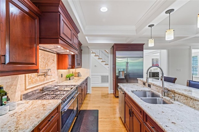 kitchen with a sink, high end appliances, light wood-type flooring, backsplash, and premium range hood