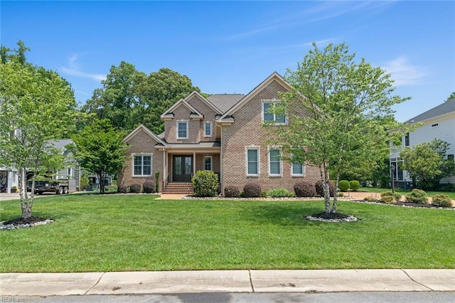 craftsman-style home featuring a front yard, french doors, and brick siding