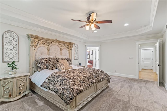 bedroom with a tray ceiling, light carpet, crown molding, recessed lighting, and baseboards