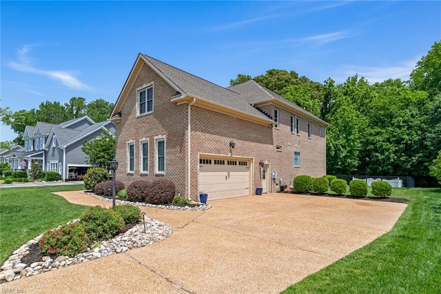 view of side of property with brick siding, driveway, a yard, and a garage