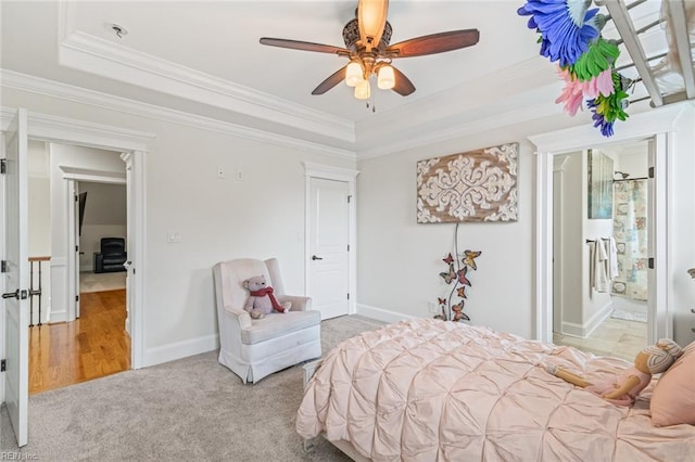 bedroom with a tray ceiling, crown molding, carpet, baseboards, and ceiling fan