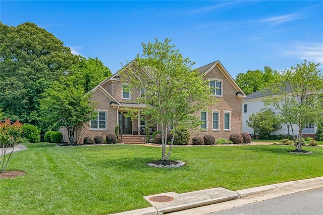 view of front of property with a front lawn and brick siding