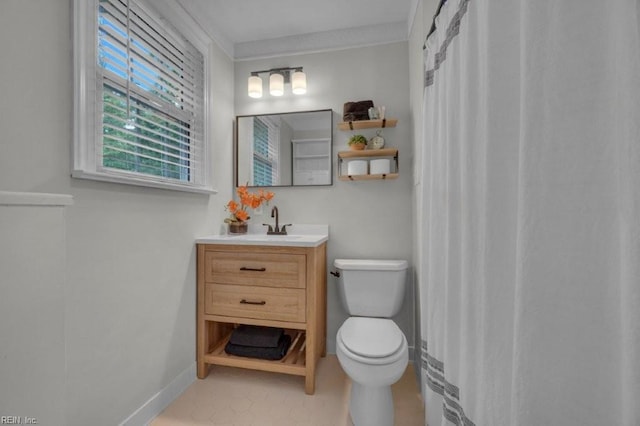 bathroom featuring toilet, vanity, and baseboards