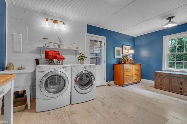 washroom featuring wood finished floors, independent washer and dryer, and baseboards
