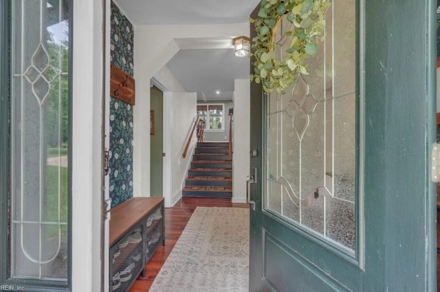 foyer entrance featuring wood finished floors, stairway, and baseboards